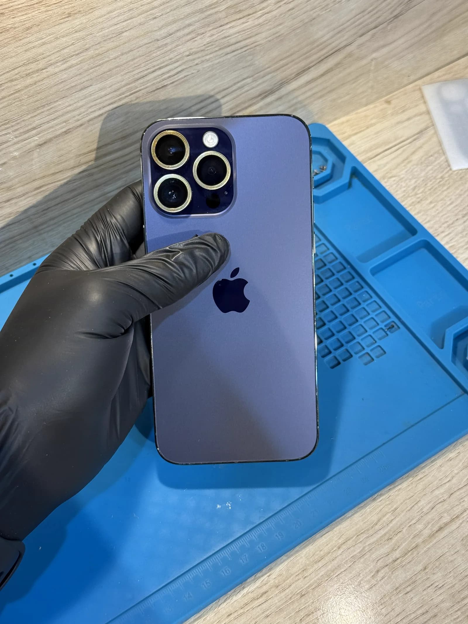Purple iPhone with restored back glass and camera surrounds after repair