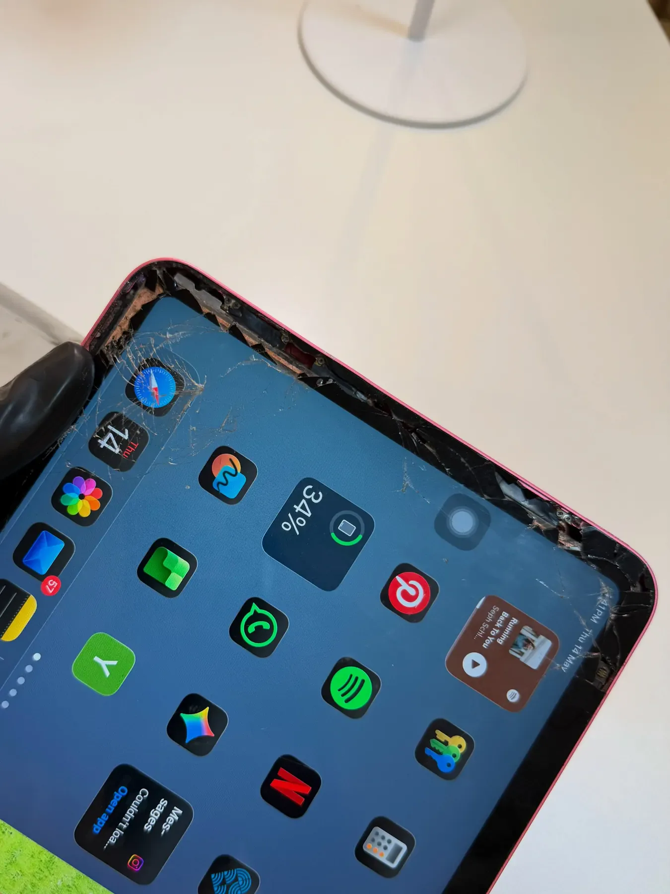 Red iPad with a badly cracked screen before repair
