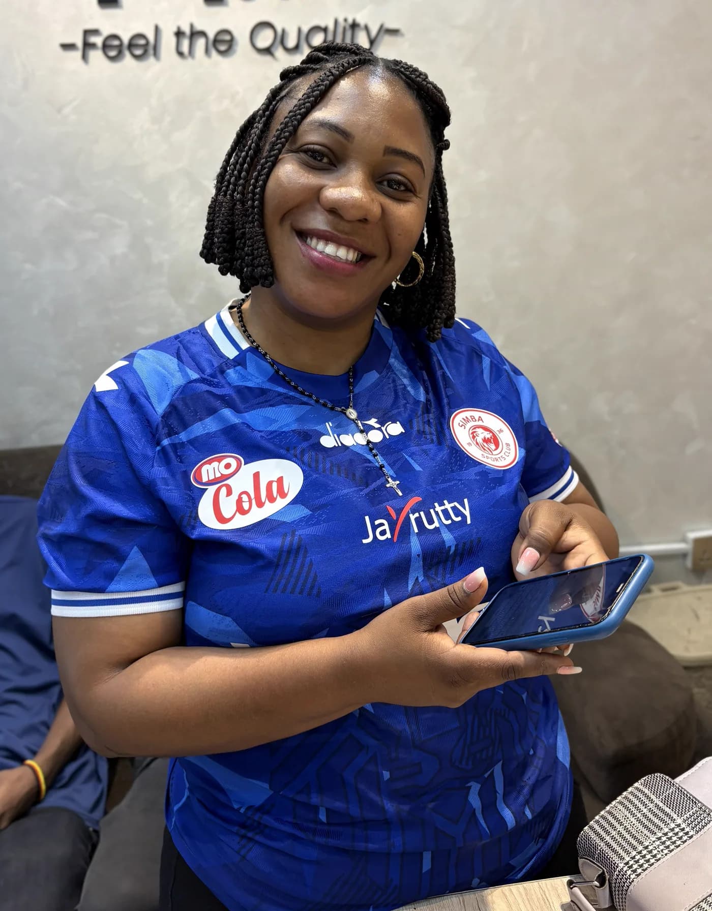 Happy customer holding her repaired phone in the service shop